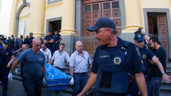 Forensic workers carry a container with a body after a shooting at Catholic cathedral in Campinas