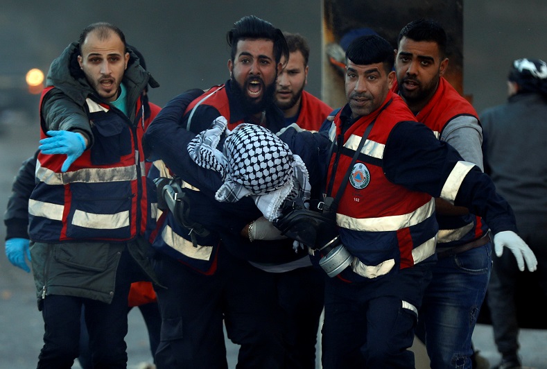 Medics evacuate a wounded Palestinian during clashes with Israeli troops near Ramallah.