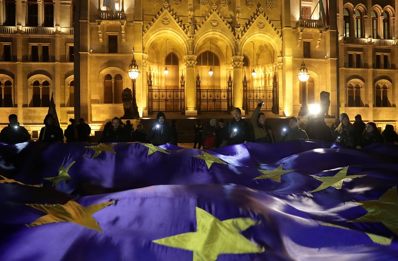 People hold a big European Union flag during a protest against a proposed new labor law, billed as the 