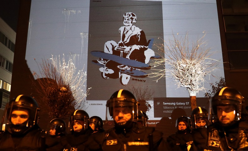 A drawing depicting Hungarian President Viktor Orban is projected on the wall of the TV building during a protest against a proposed new labor law, billed as the 