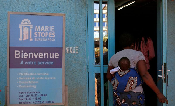 A woman carrying a baby arrives at the clinic of the NGO Marie Stopes in Ouagadougou, Burkina Faso February 16, 2018