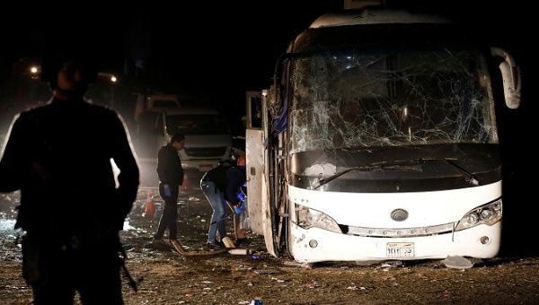 Police officers inspect a scene of a bus blast in Giza, Egypt, Dec. 28, 2018.