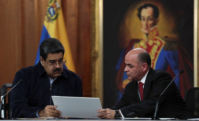President Nicolas Maduro (L) speaks with Oil Minister Manuel Quevedo during an ceremony in Caracas, Venezuela, Aug. 28, 2018.