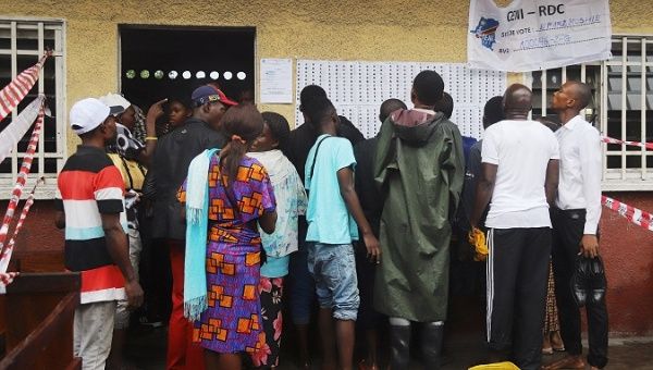 Despite heavy rain Congolese people stand in line to cast their vote.