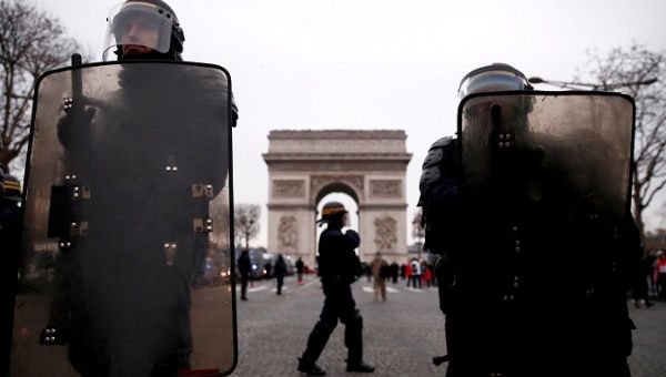 Riot police officers stand guard during a demonstration by the 