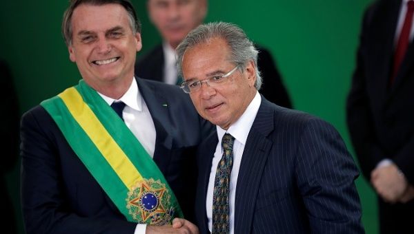 President Jair Bolsonaro (L) shakes hands with Paulo Guedes, economy minister, in Brasilia, Brazil Jan. 1, 2019.