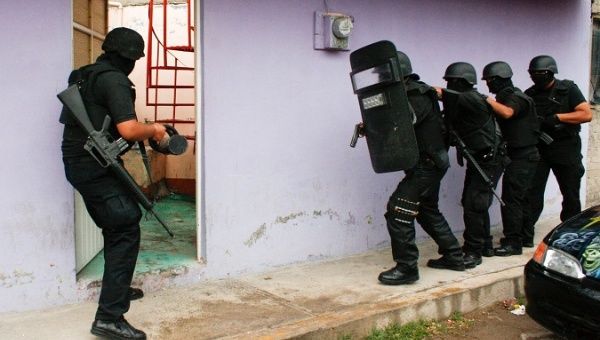 Members of Mexico's anti-kidnapping police break into a house to rescue two people in May 2010, Nezahualcoyotl.