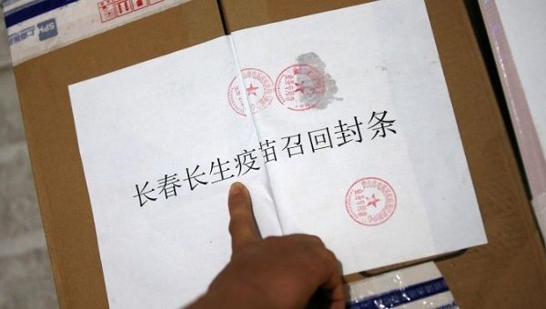 A staff from a local disease prevention and control centre points to a paper notice for recall on a sealed package of vials containing the rabies vaccines manufactured by the vaccine maker Changsheng Biotechnology in Huangshan, Anhui province, China July 23, 2018. 
