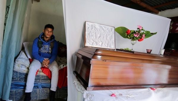 A relative sits next to the coffin of Heydi Betanco, 18, one of the five people who were shot dead on Jan. 10 during a wake, in Tegucigalpa, Honduras, Jan. 11, 201