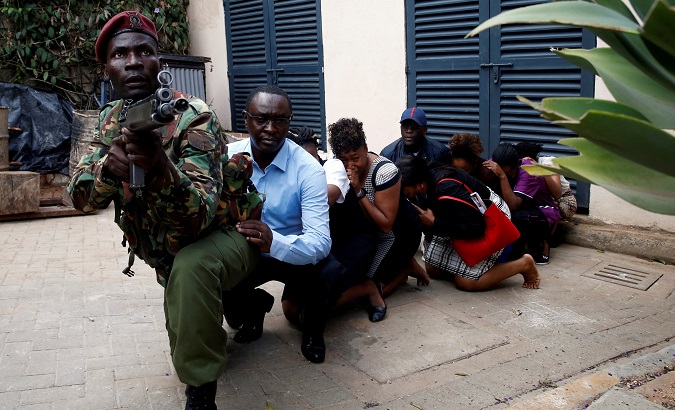 People are evacuated by a member of security forces while explosions and gunshots were heard at the Dusit hotel compound, in Nairobi, Kenya Jan. 15, 2019.