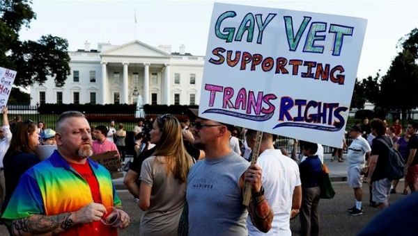 Demonstrators gather to protest US President Donald Trump's announcement that he plans to reinstate a ban on transgender individuals serving in any capacity in the US military
