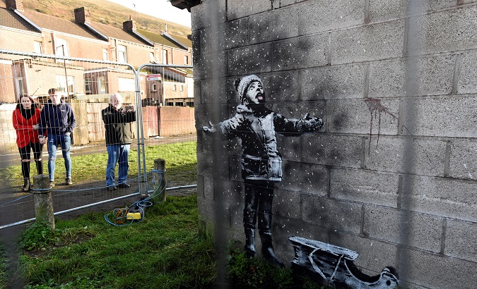 People view new work by the artist Banksy that appeared during the week on the walls of a garage in Port Talbot, Britain December 22, 2018. REUTERS/Rebecca Naden/File Photo