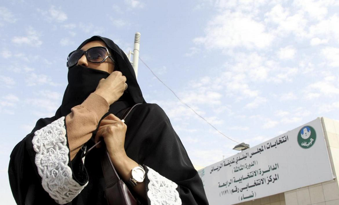 A Saudi woman leaves a polling station after casting her vote during municipal elections, in Riyadh, Saudi Arabia Dec. 12, 201