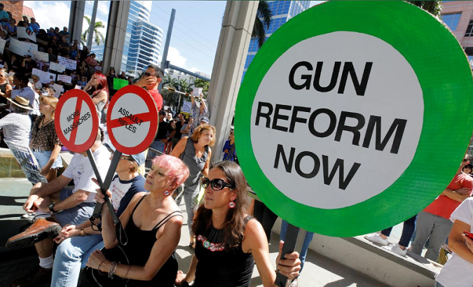 Protesters hold signs as they call for a reform of gun laws three days after the shooting at Marjory Stoneman Douglas High School, at a rally in Fort Lauderdale, Florida, U.S., Feb. 17, 2018.