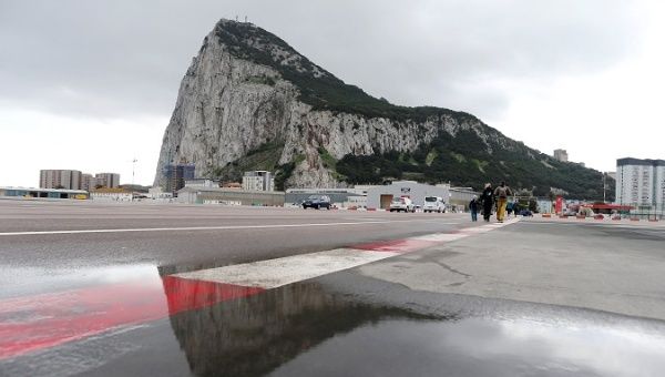 Pedestrians cross the tarmac at Gibraltar International Airport, near the border with Spain in the British overseas territory of Gibraltar, historically claimed by Spain. 