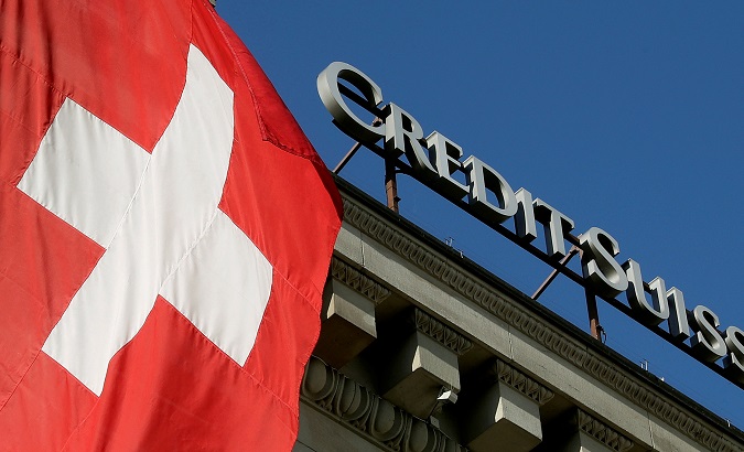 FILE PHOTO: Switzerland's national flag flies next to the logo of Swiss bank Credit Suisse at a branch office in Luzern, Switzerland Oct. 19, 2017.