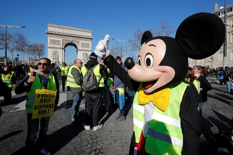 A protester wearing a Mickey Mouse costume reacts near the Arc de Triomphe in Paris, France, Feb. 23, 2019. 