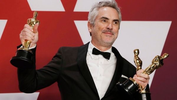 Alfonso Cuaron of Mexico poses backstage with his Best Director, Best Foreign Language Film and Best Cinematography awards for 