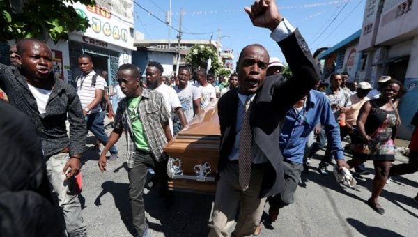 Local residents carry the casket of a man shot dead during anti-government protests in Port-au-Prince, Haiti.