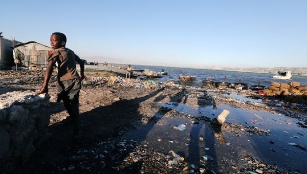 A child walks along a garbage-polluted sea shore in Port-au-Prince, Haiti.