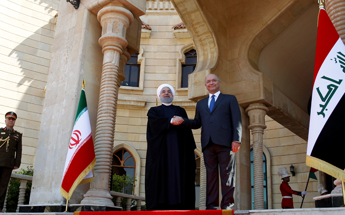 Iraq's President Barham Salih shakes hands with Iranian President Hassan Rouhani during a welcome ceremony at Salam Palace in Baghdad, Iraq March 11, 2019