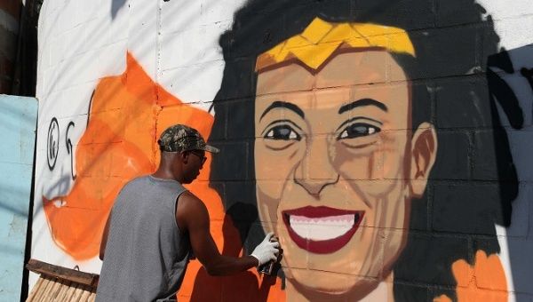 A man paints Marielle Franco's face and demands punishment of the guilty in Rio de Janeiro, Brazil, Mar. 18, 2018.