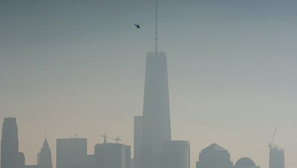 A helicopter flies over the Hudson River with One World Trade Center and Lower Manhattan in the background, on a hazy day in New York City, Dec. 6, 2015. 