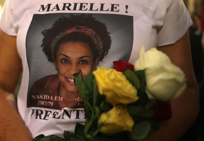 A woman wears a shirt with Marielle Franco’s face saying “Marielle is here” during a demonstration.