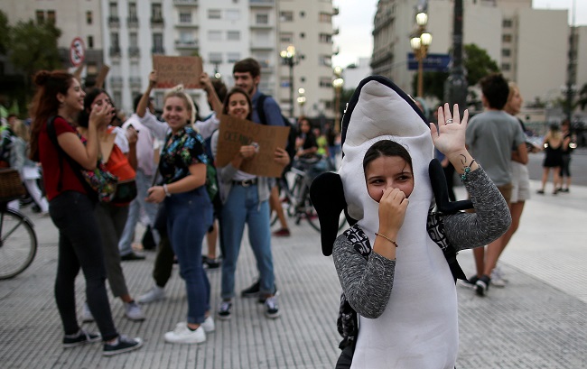 A student dress as a killer whale dances during a protest to demand global action on climate change as part of the 