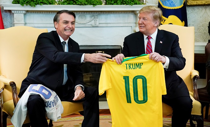 Brazil's President Jair Bolsonaro presents a Brazil national football jersey to U.S. President Donald Trump after receiving the U.S. jersey from Trump during a meeting in the Oval Office of the White House in Washington, U.S.