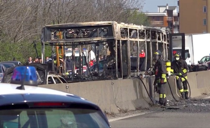 The wreckage of a bus that was set ablaze by its driver in protest against the treatment of migrants trying to cross the Mediterranean Sea, is seen on a road in Milan, Italy.