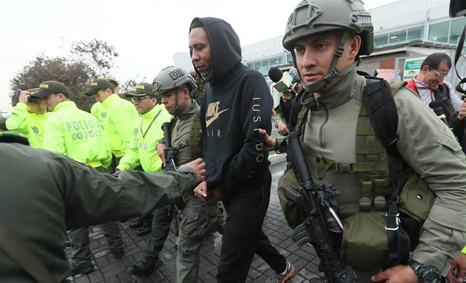 Former Colombian footballer Jhon Viafara is escorted by members of the Colombian Police Wednesday as he arrives at the Anti-narcotics Directorate at the Military Airport of Catam in Bogota.