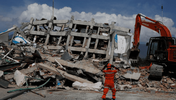 A rescue team member in front of a hotel damaged from earthquake hit in Palu, Sulawesi Island, Indonesia, October 2, 2018