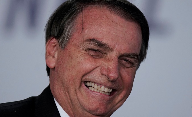 Brazil's President Jair Bolsonaro smiles during a signing ceremony for 13.2 billion reais in contracts for electricity transmission lines, at the Planalto Palace in Brasilia, Brazil March 25, 2019.