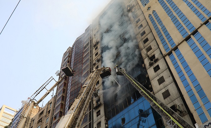 Firefighters attempt to extinguish a fire at a multi-story commercial building in Dhaka.