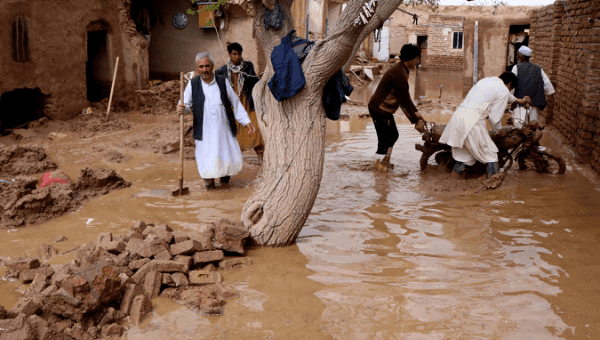 People wading through flood waters in Herat province, Afghanistan March 29, 2019. 