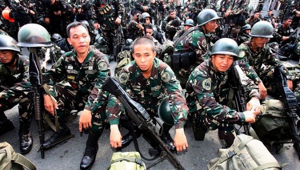 Filipino soldiers await orders to board a Navy ship.