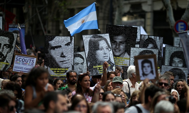 Demonstrators hold images of people who disappeared, during the march towards Plaza de Mayo square to commemorate the 43rd anniversary of the 1976 military coup, in Buenos Aires, Argentina March 24, 2019.