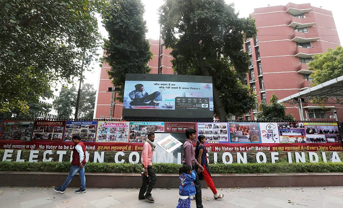 People walk past the Election Commission of India office building in New Delhi, India.