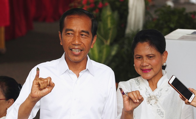 Indonesian President Joko Widodo and first lady Iriana Joko Widodo show their ink-stained fingers after casting their ballots.