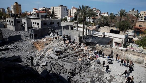 Palestinians inspect a destroyed Hamas site after it was targeted by an Israeli air strike in Gaza City March 26, 2019.