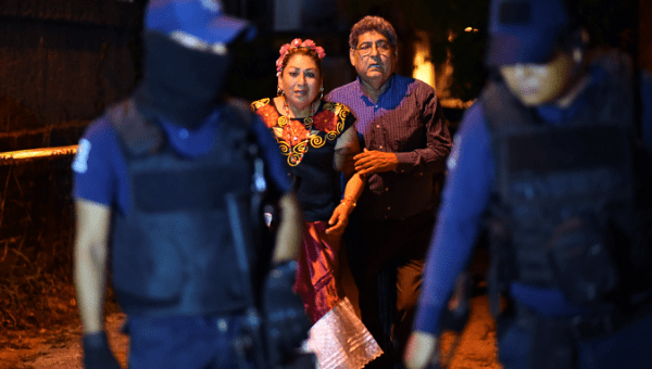 People with police officers who guard a crime scene where unidentified assailants opened fire at a bar in Minatitlan, in Veracruz state, Mexico, April 19, 2019.