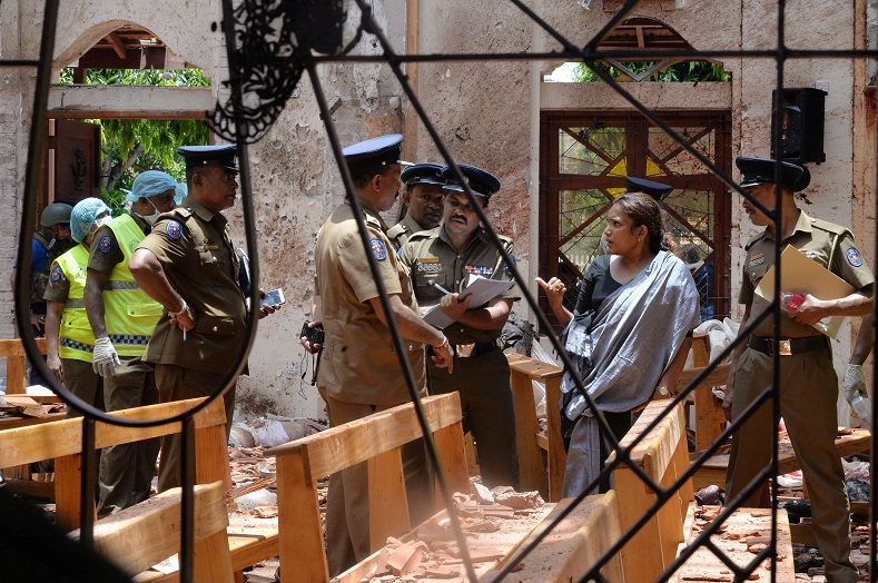 Crime scene officials inspect the site of a bomb blast inside a church in Negombo, Sri Lanka April 21