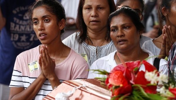 People attend a mass burial of victims at a cemetery near St. Sebastian Church in Negombo