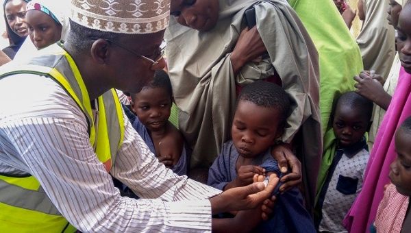 A Nigerian doctor vaccinates a group of children against meningitis.