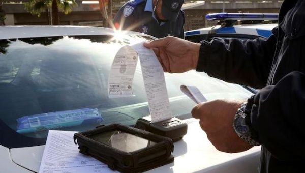 A traffic officer prints out a fine for an Uber driver who operates without a permit in Cape Town, South Africa, May 4, 2019. 