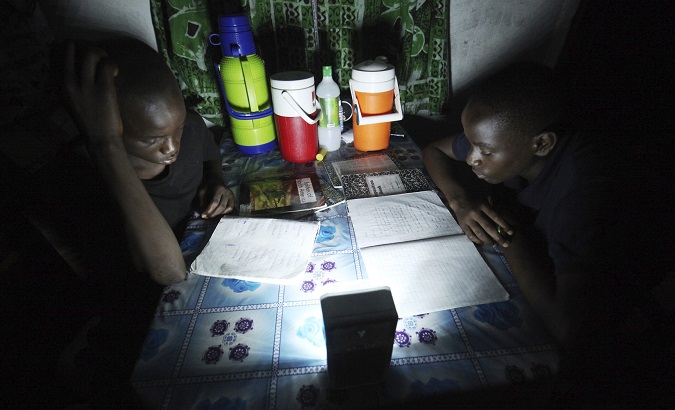 Students study with a small light during a power outage.