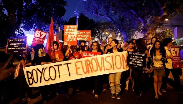 Protesters hold banners and placards as they take part in a demonstration calling for an end to Israel's policy towards Gaza and a boycott of the 2019 Eurovision Song Contest as the first semi final of the contest begins in Tel Aviv, Israel