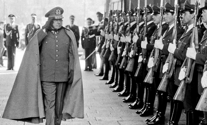 Former Dictator Pinochet reviews troops inside the presidential palace.