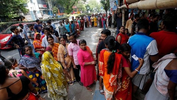 Voters stand in queues as they wait to cast their vote outside a polling station during the final phase of general election in Kolkata, India, May 19, 2019.